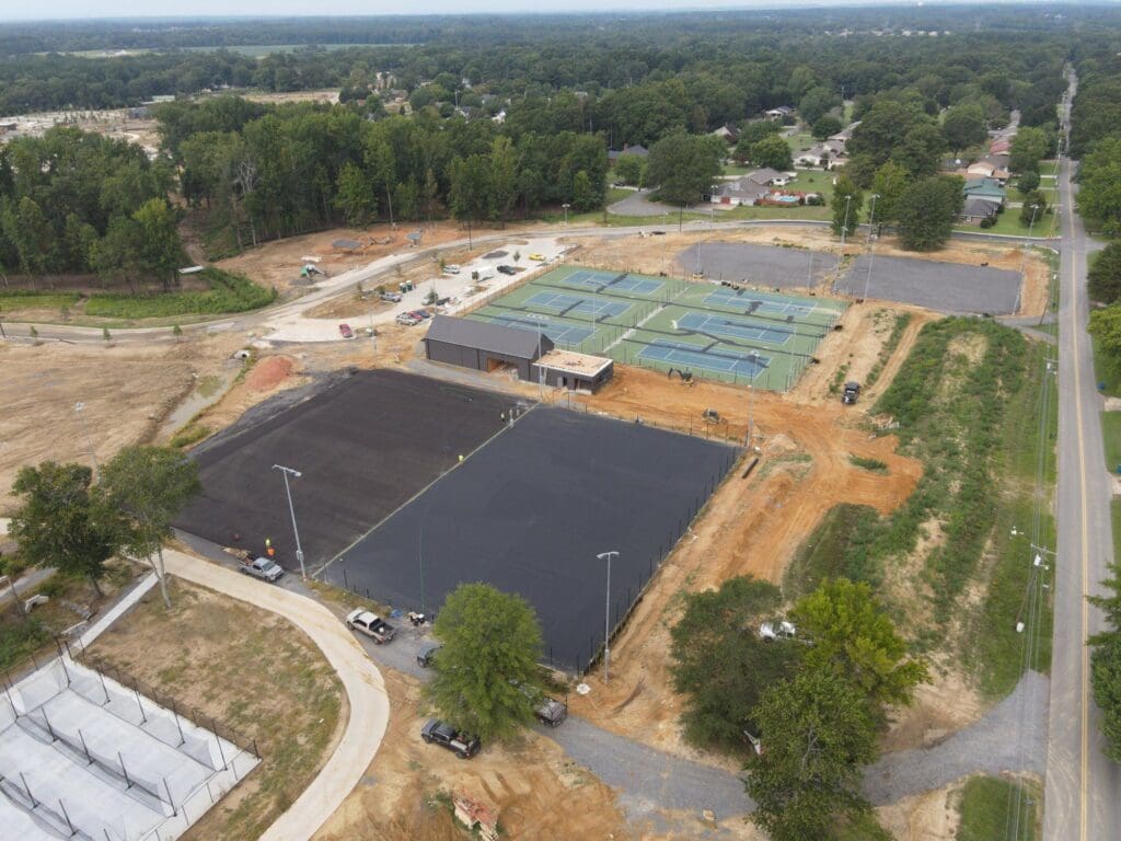 An aerial view of a tennis court and the construction site.