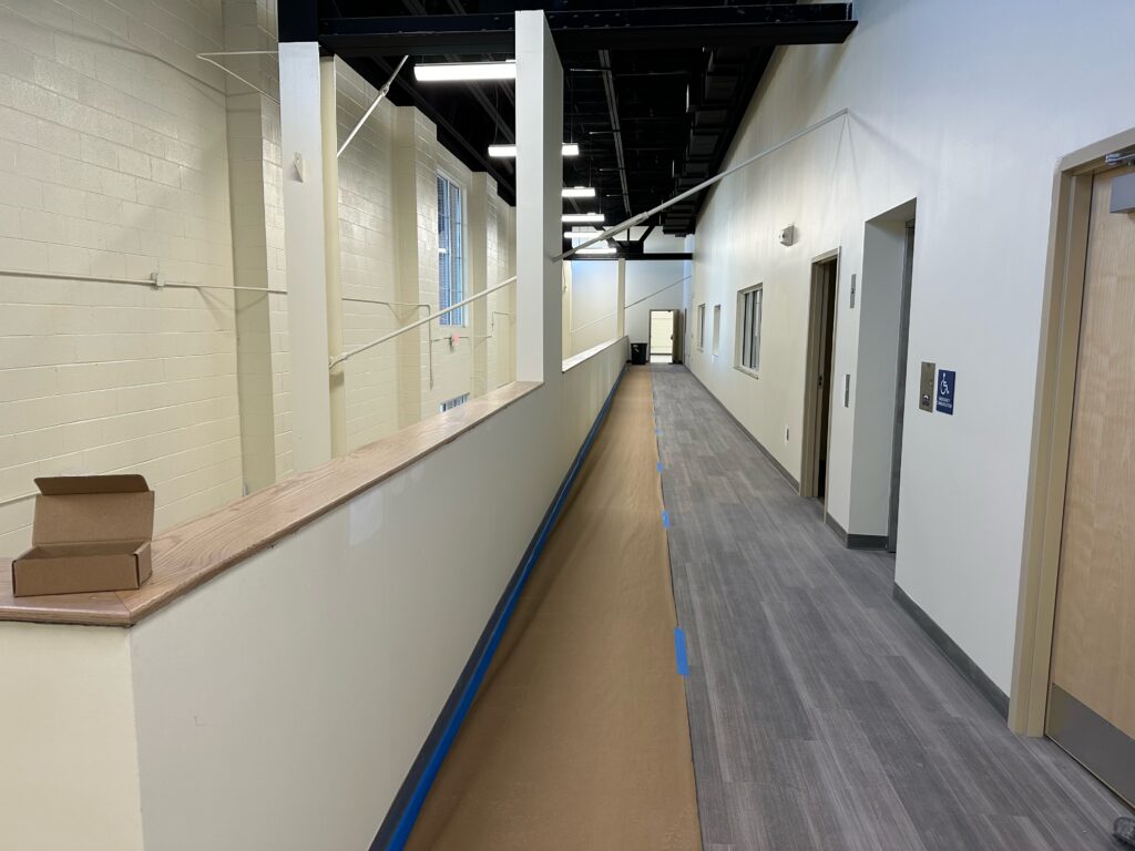 Hallway with new flooring and blue tape.