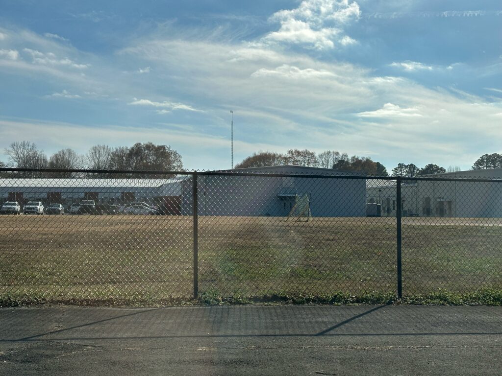 Chain link fence with a building behind it.