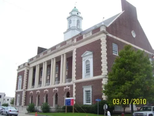 Brick building with a clock tower and columns.