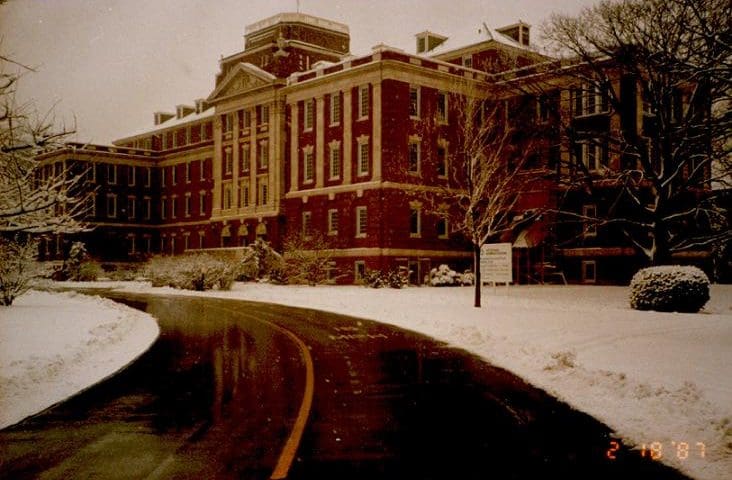 Brick building with snowy driveway.