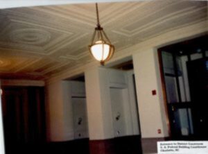 Ornate chandelier in a courthouse hallway.