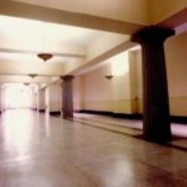 Empty hallway with columns and tiled floor.