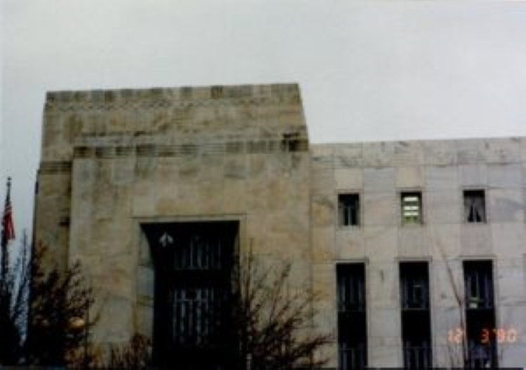 Stone building with large windows and a flag.